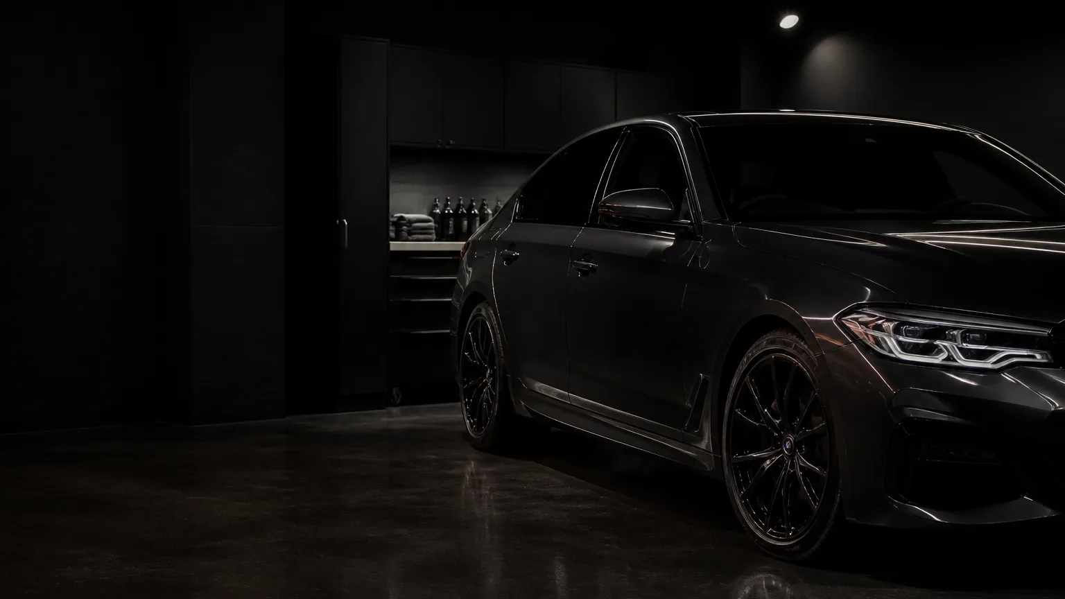 Dark sedan in a controlled automotive detailing studio.